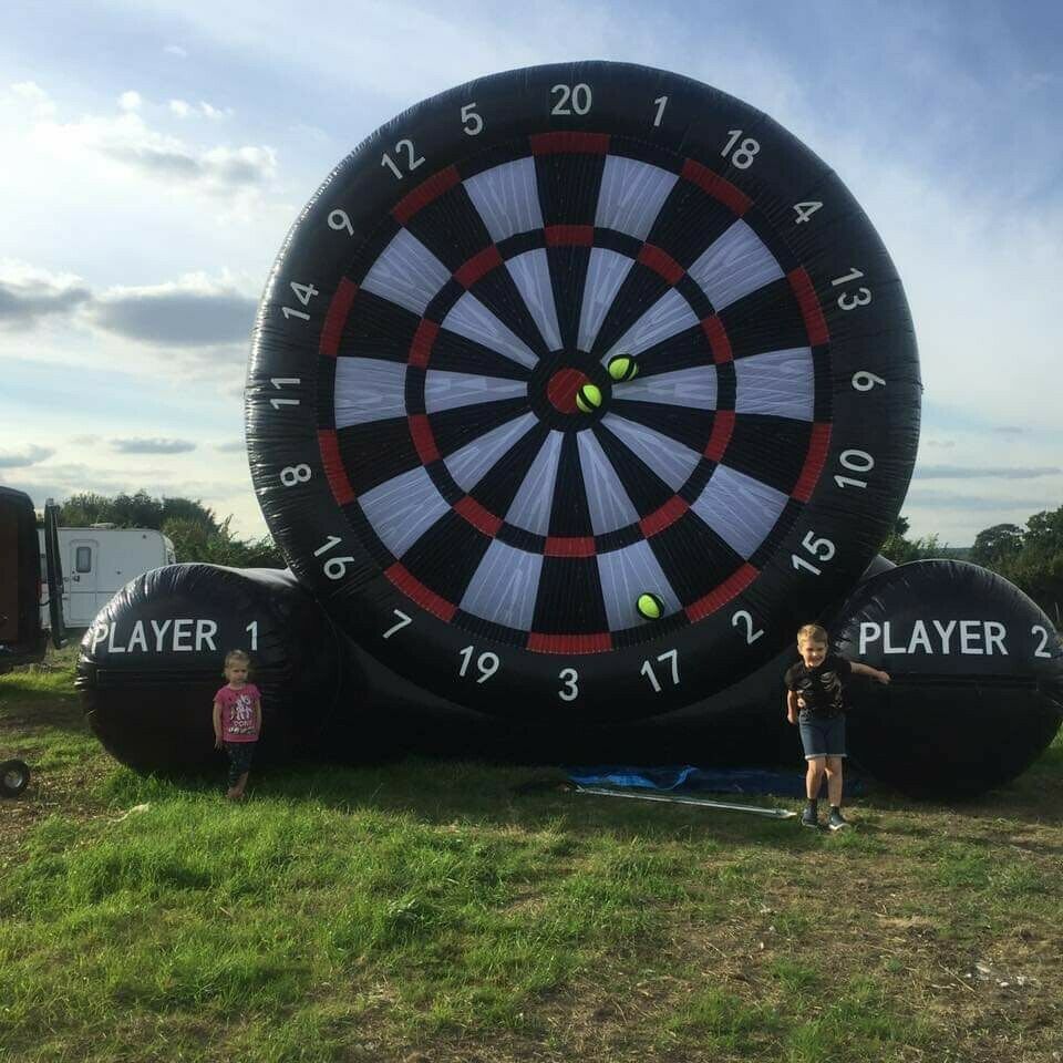 Our Big Impact Giant Inflatable Dartboard game set up to look visually impressive, with a man in action, kicking a football to get a score at a Corporate Fun Day event.