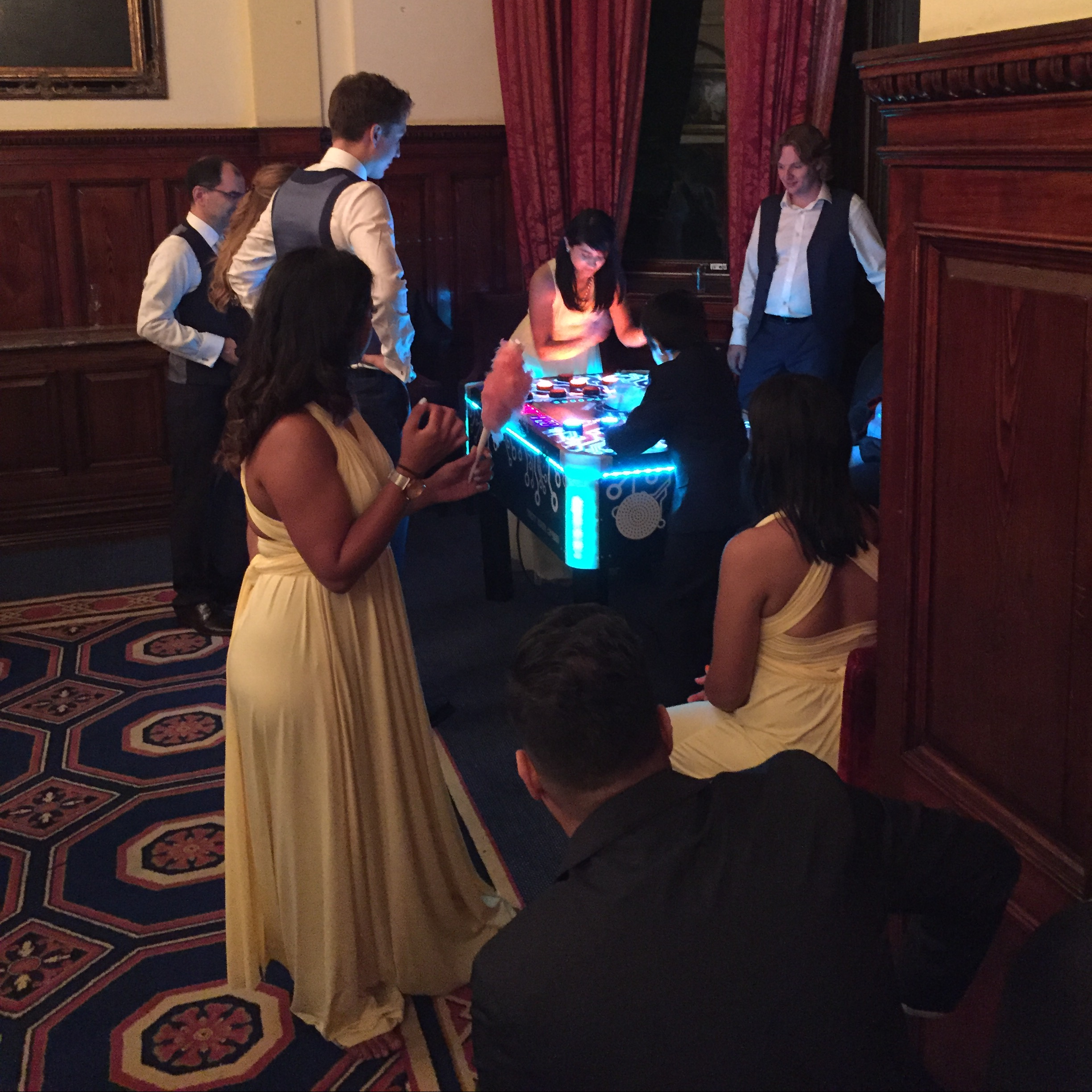bride, groom and wedding guest at a hotel evening reception with electronic and tabletop games