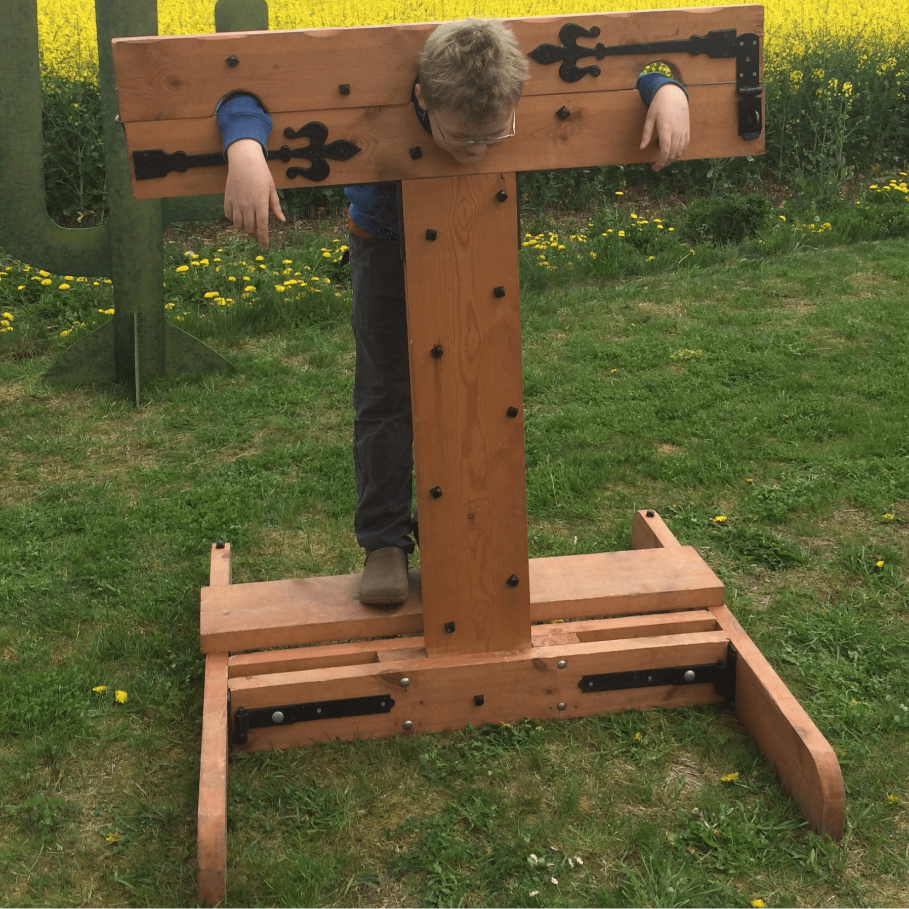 A boy standing in the stocks at a Village Fete waiting for those wet sponges!