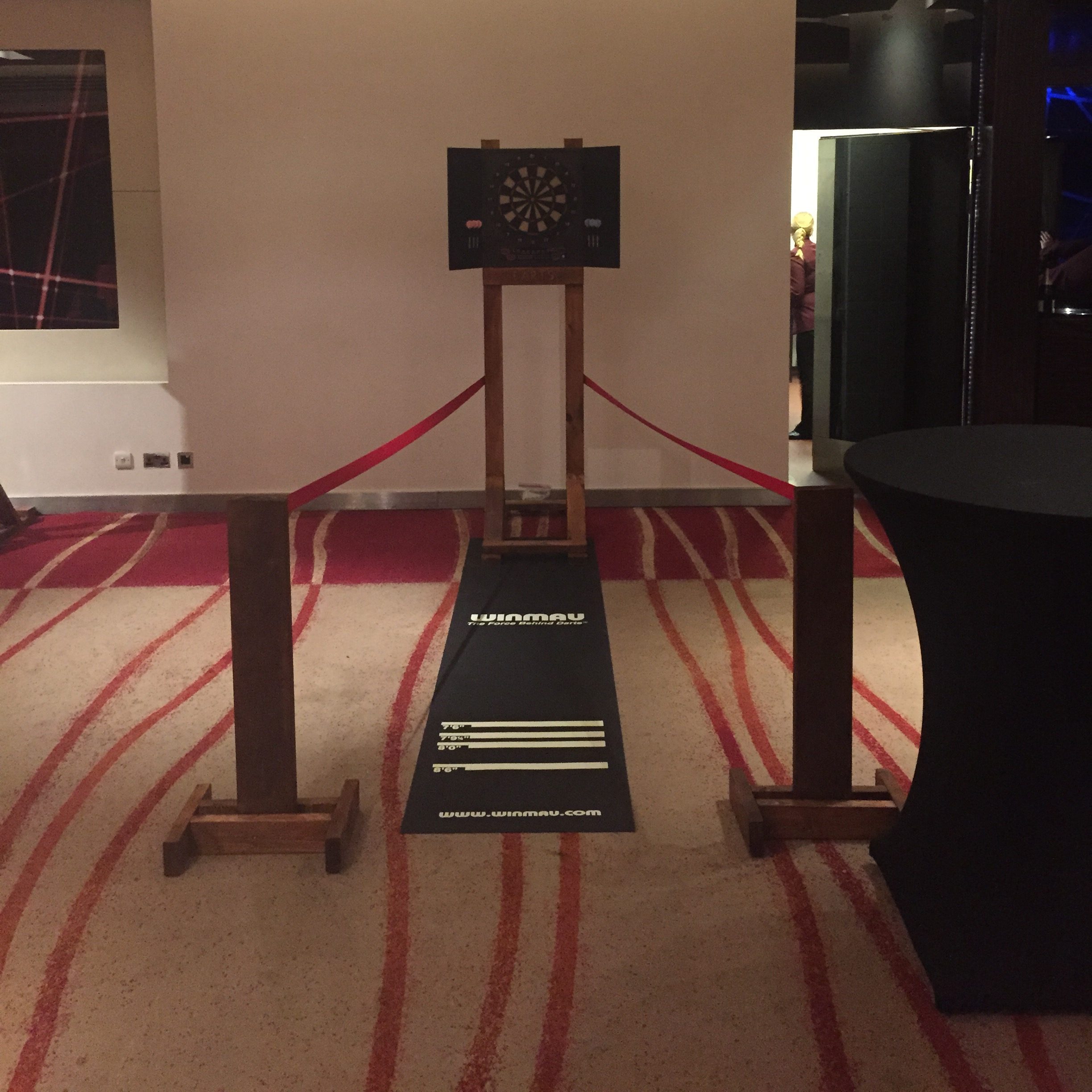 Our Electronic Dartboard with our bespoke wooden frame, rubber dart mat, premium rope red rope barrier and bespoke hand-made barrier stands, all set out for play.