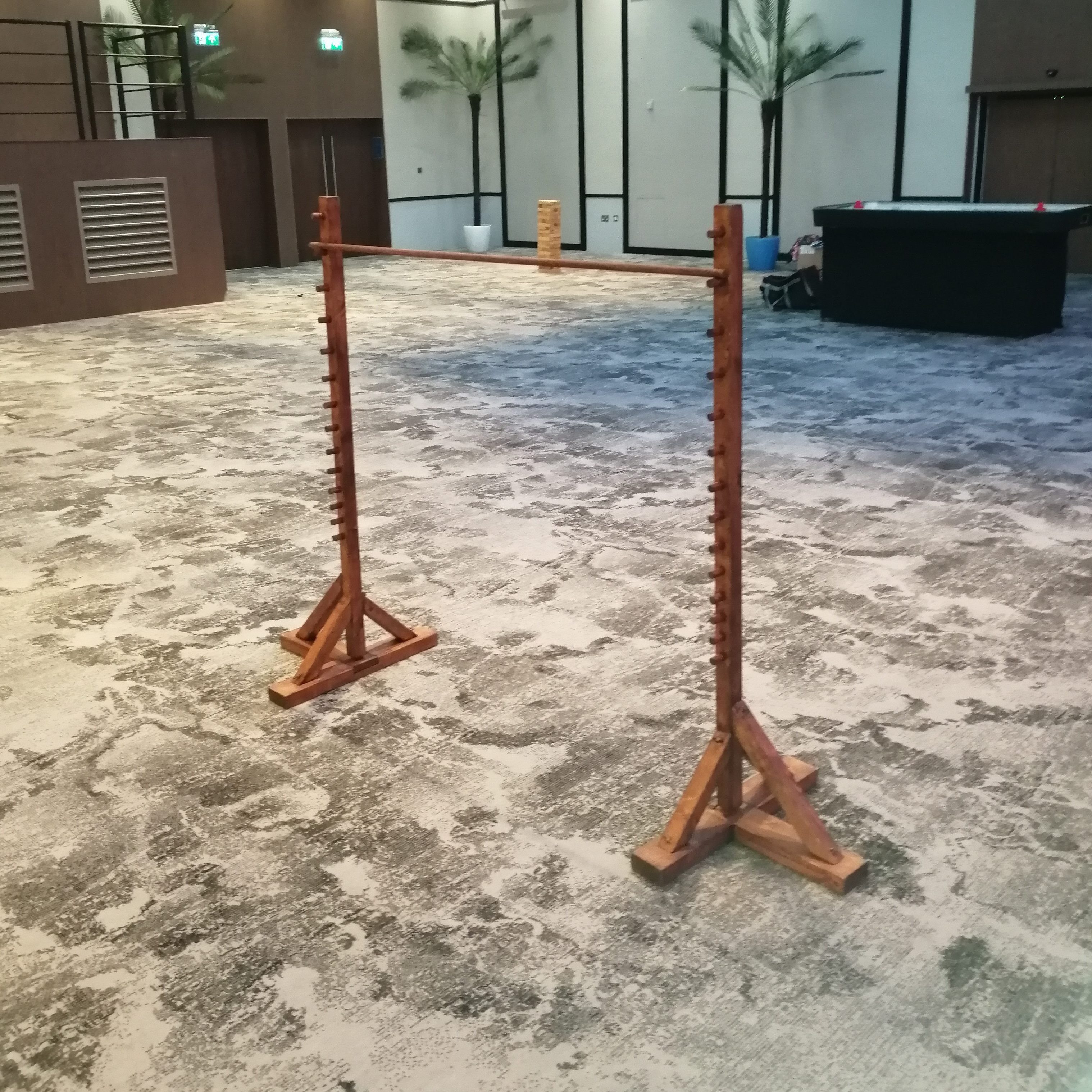 A wooden set of Limbo hired and set up in a hotel business room for an indoor event.