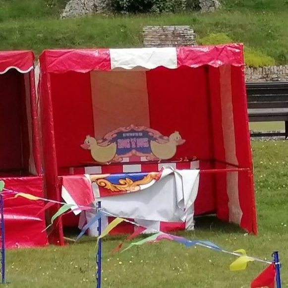 Our bright red and white striped Fete Game Side Stall set up with our Hook a Duck game.
