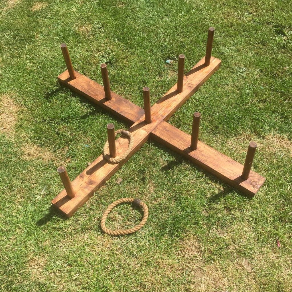 Our hand-made wooden Giant Quoits game set out on grass with a couple of the rope hoops.