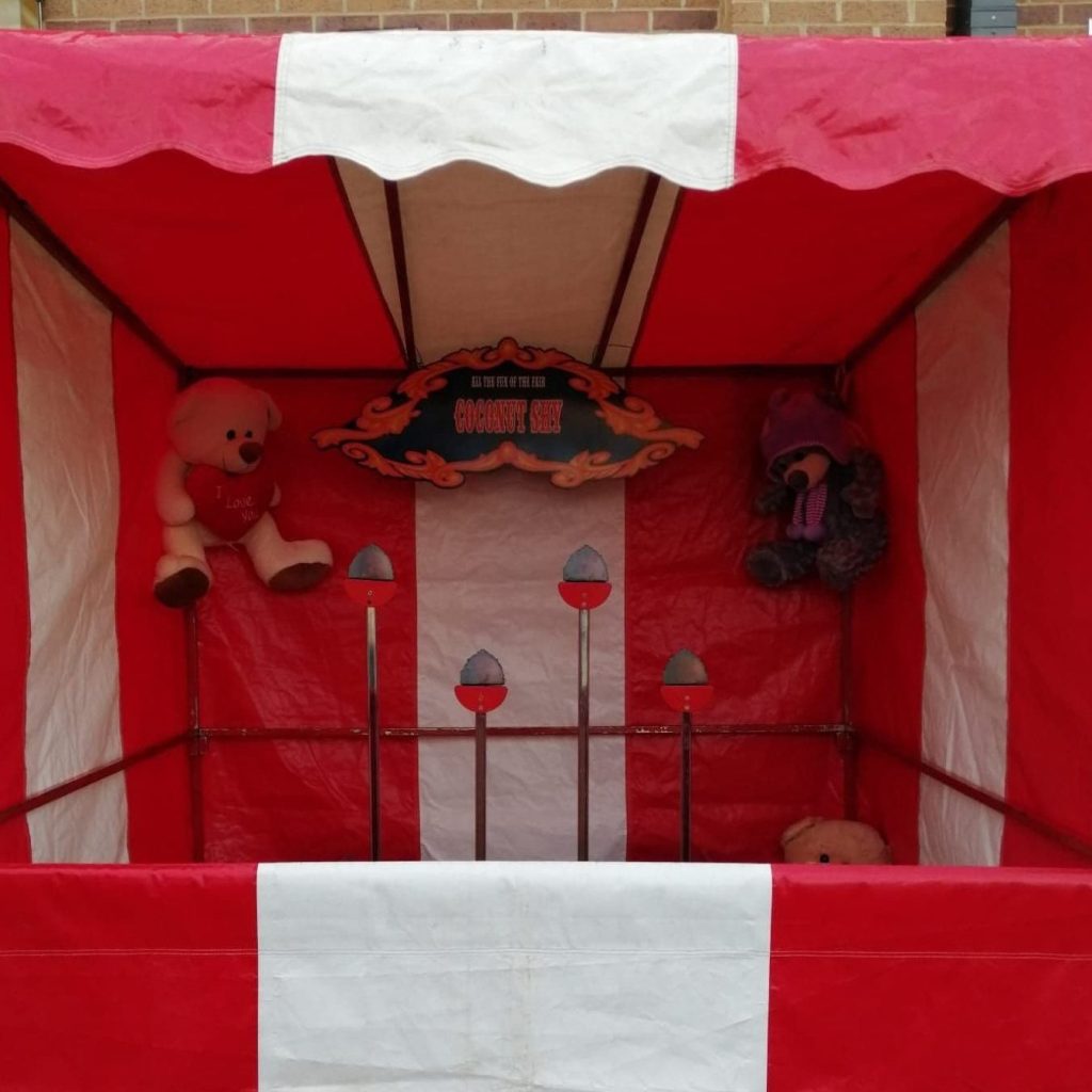Our bright red and white striped Fete Game Side Stall set up with our Coconut Shy game.