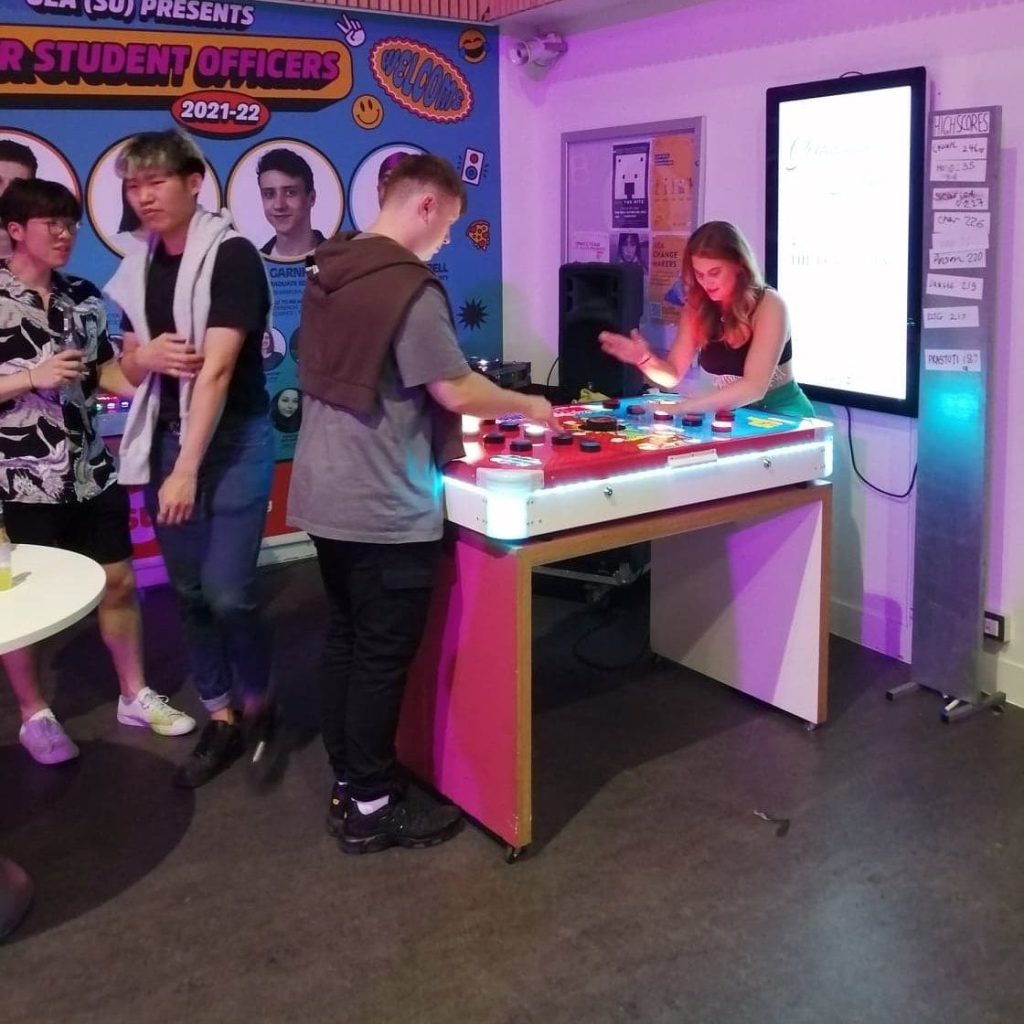 College students enjoying a competitive challenge with our hired in Chase the Lights speed reaction game.