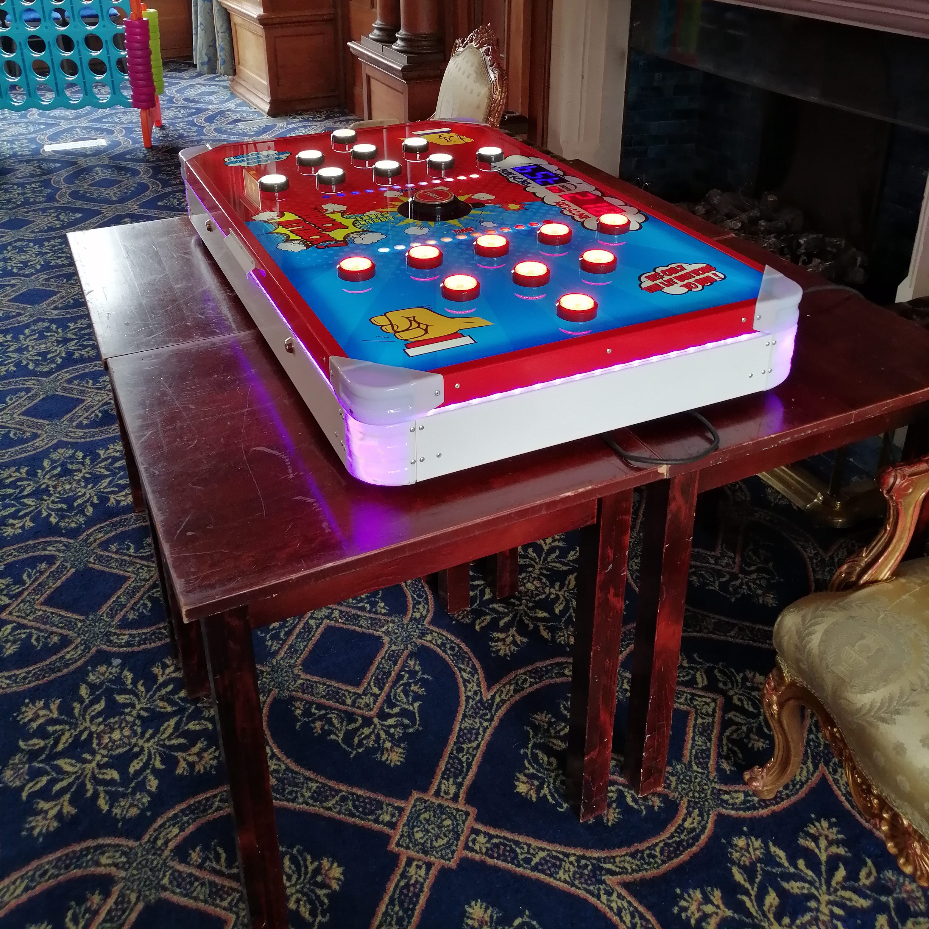 Our Chase the Lights game set out on a table for an indoor event, with its decorative cartoon pattern and flashing buttons.