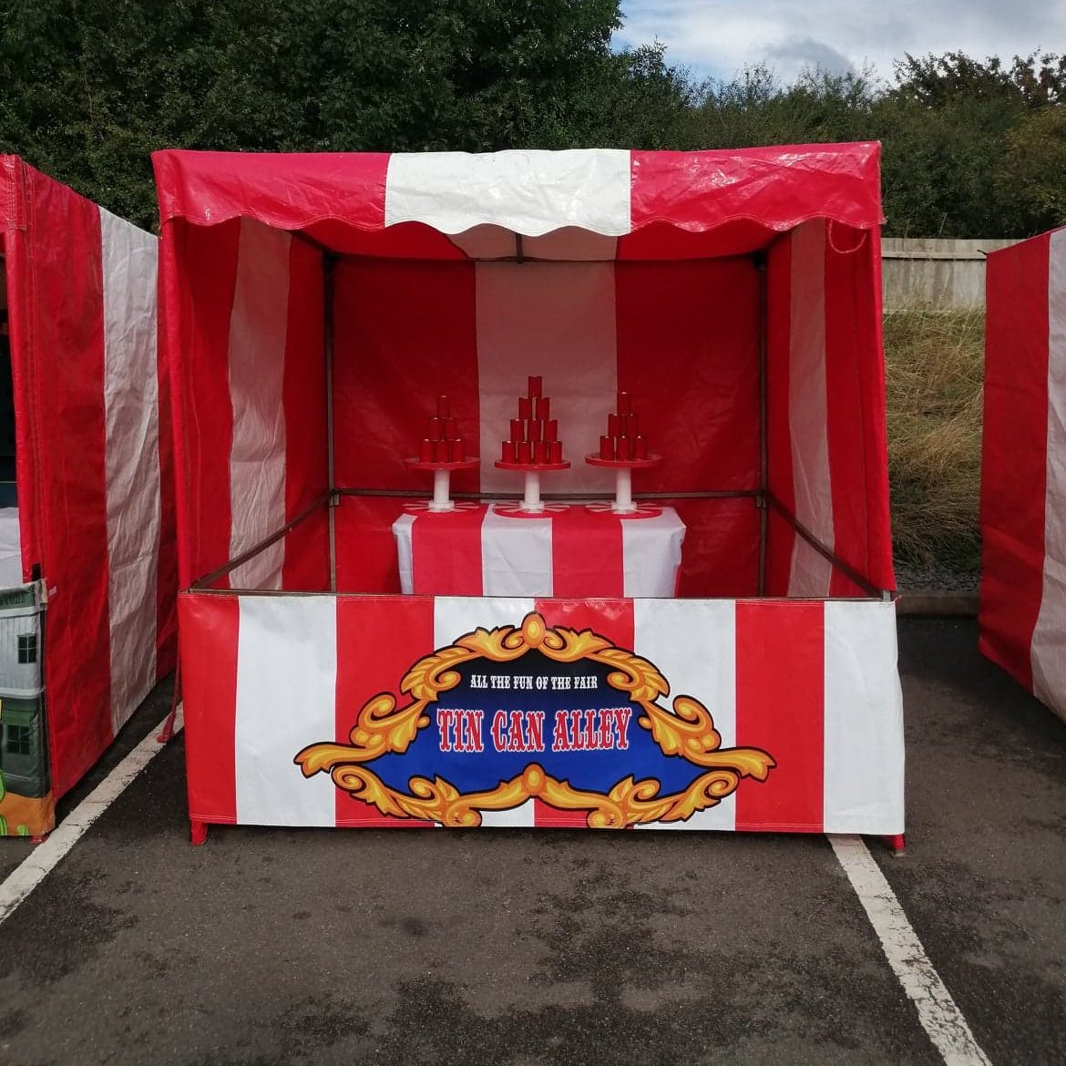 Our bright red and white striped Fete Game Side Stall set up with our Tin Can Alley game.