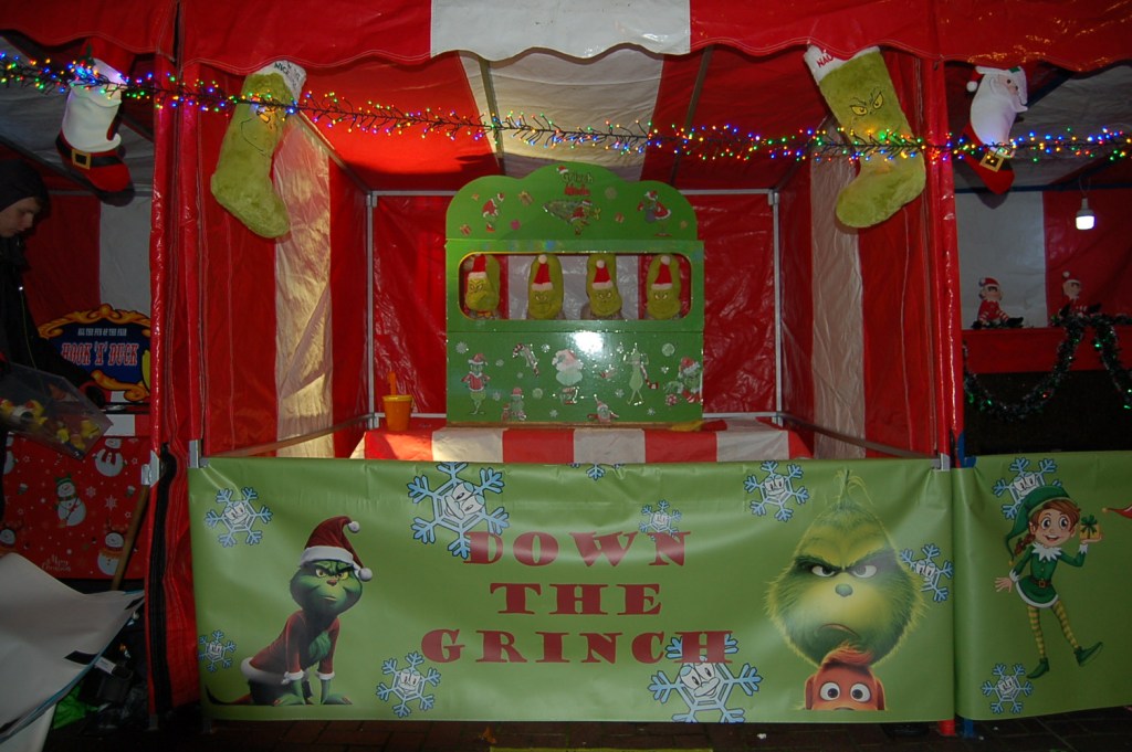 Christmas festive signage for our classic Side Stall Down a Grinch game with tinsel and Grinch decorations.