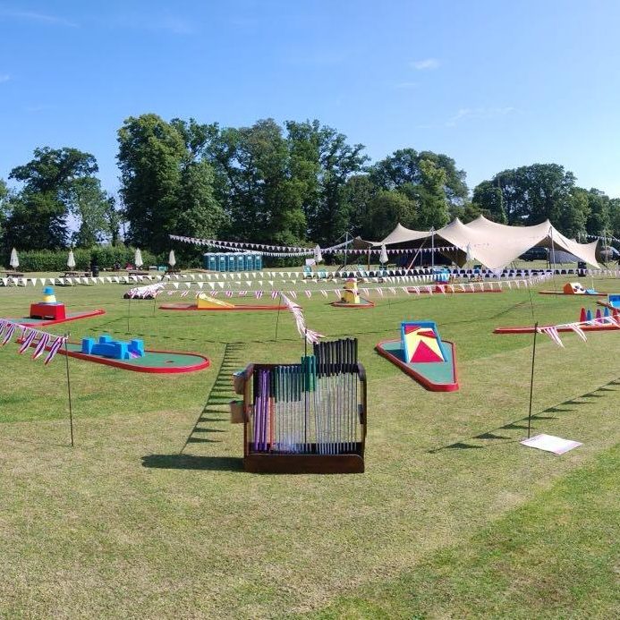 Beautifully set out Crazy Golf with bespoke holder for golf clubs and golf balls, with colourful bunting to set up a course at a Centenary School event.