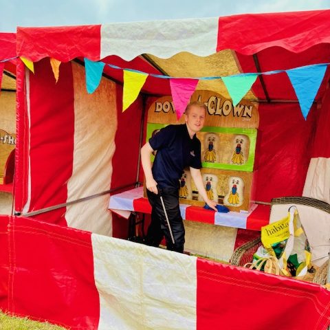 A happy member of our team getting the beanbags gathered for the next player of our Down the Clown Carnival Side Stall game.