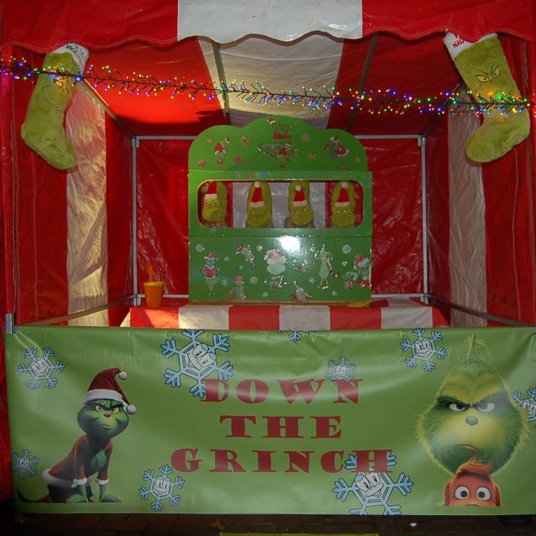 A red and white Carnival Fete Side Stall with Santa Ducks ready to be hooked and a decorated banner at the front of the stall.
