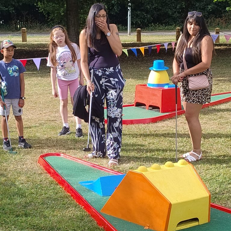 A snapshot of a School Fete with our Crazy Golf, ready for use and being played on by parents and children.