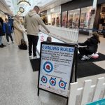 People playing on our Curling Lane with a sign on an A frame explaining the rules of the game.