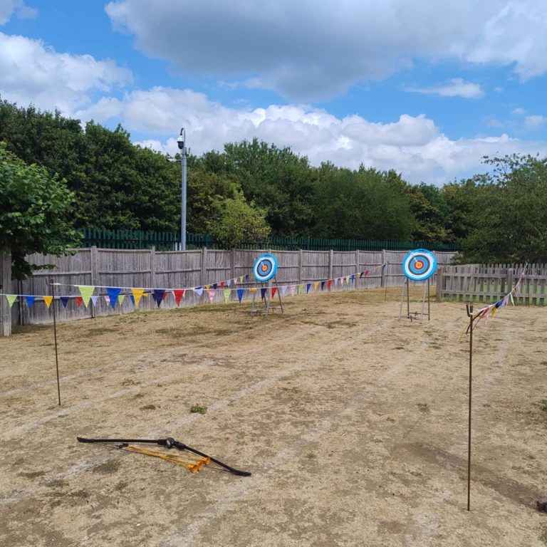 Our Safe Archery on stands set up in two lanes that are marked out with bright colourful bunting, with the bow and arrows position ready for play.