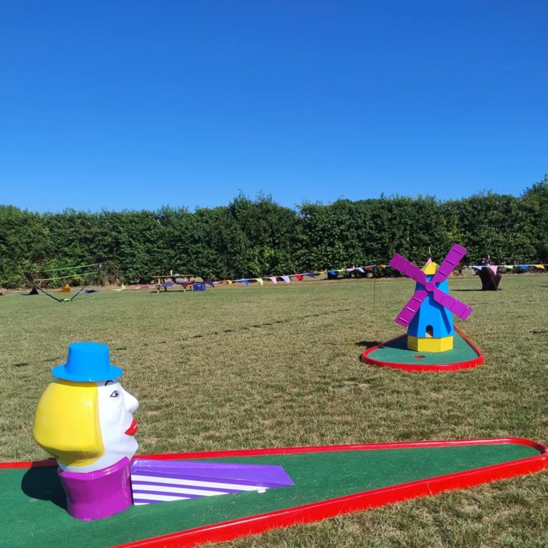 Our Man's Head and Windmilll (with its striking purple sails) Crazy Golf obstacles sat on their red bases with artificial grass.
