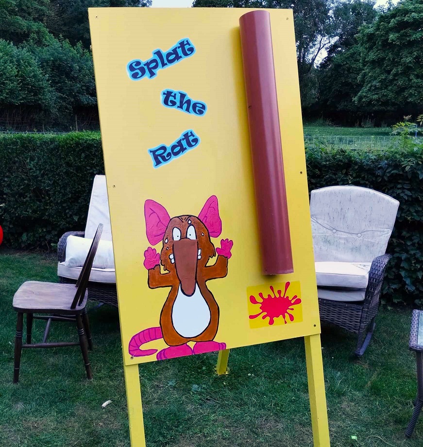 Our bespoke, hand-painted Splat the Rat Garden game with its yellow background, gutter tubing and cute image of a rat with its hands up.