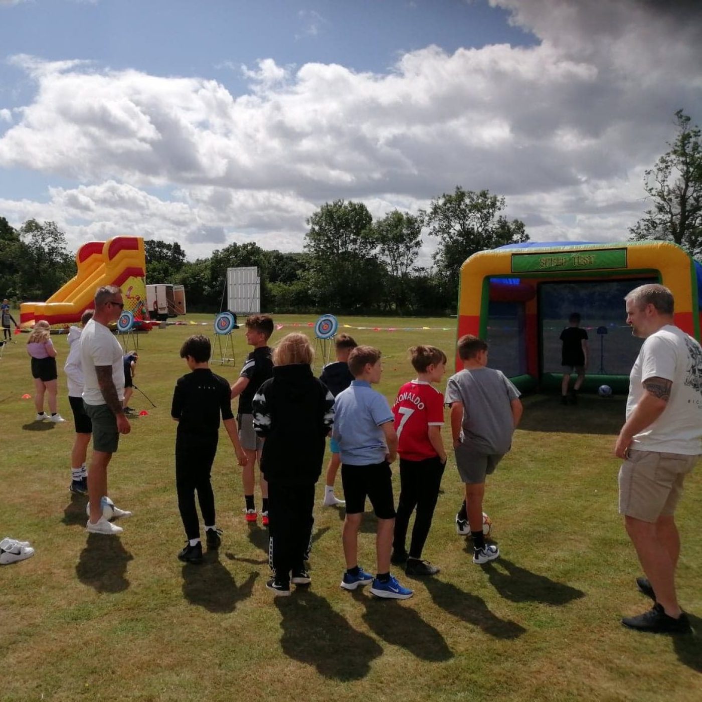 A group of teenagers playing our Inflatable Speed Cage at a Village Fete.