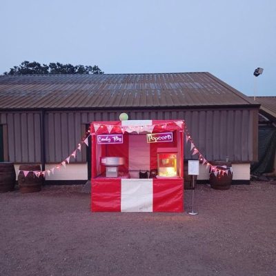 One of our Fete Game Side Stalls, decorated with bunting and lights, set up ready to offer Popcorn and Candyfloss to event goers.