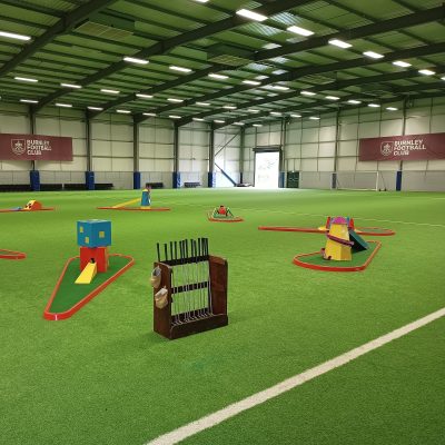 Crazy Golf hired and set up for an indoor event with our bespoke wooden holder for the golf clubs and golf balls.