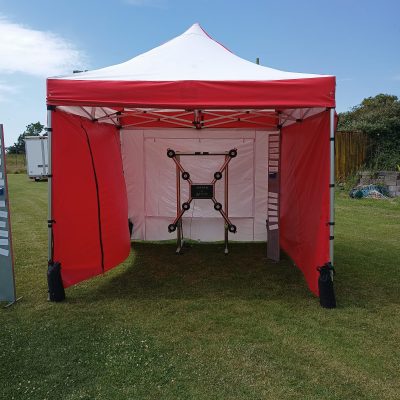 Our Batak Lite Electronic Game housed in one of our red and white striped Fete Game Side Stalls for an outdoor event that isn't spoiled by the sun.