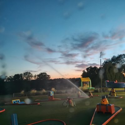A beautiful photo of our 9 hole Crazy Golf and obstacles at dusk with the sprinklers turned on