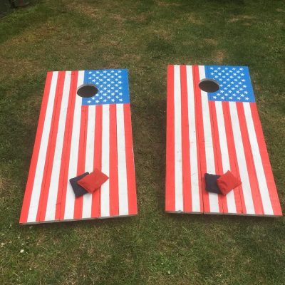 Our bespoke hand-painted Cornhole Toss Garden game with the traditional American flag design, and beanbags set up ready.