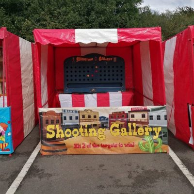Our bright red and white striped Fete Game Side Stall set up with our Cork Shooting Gallery game.